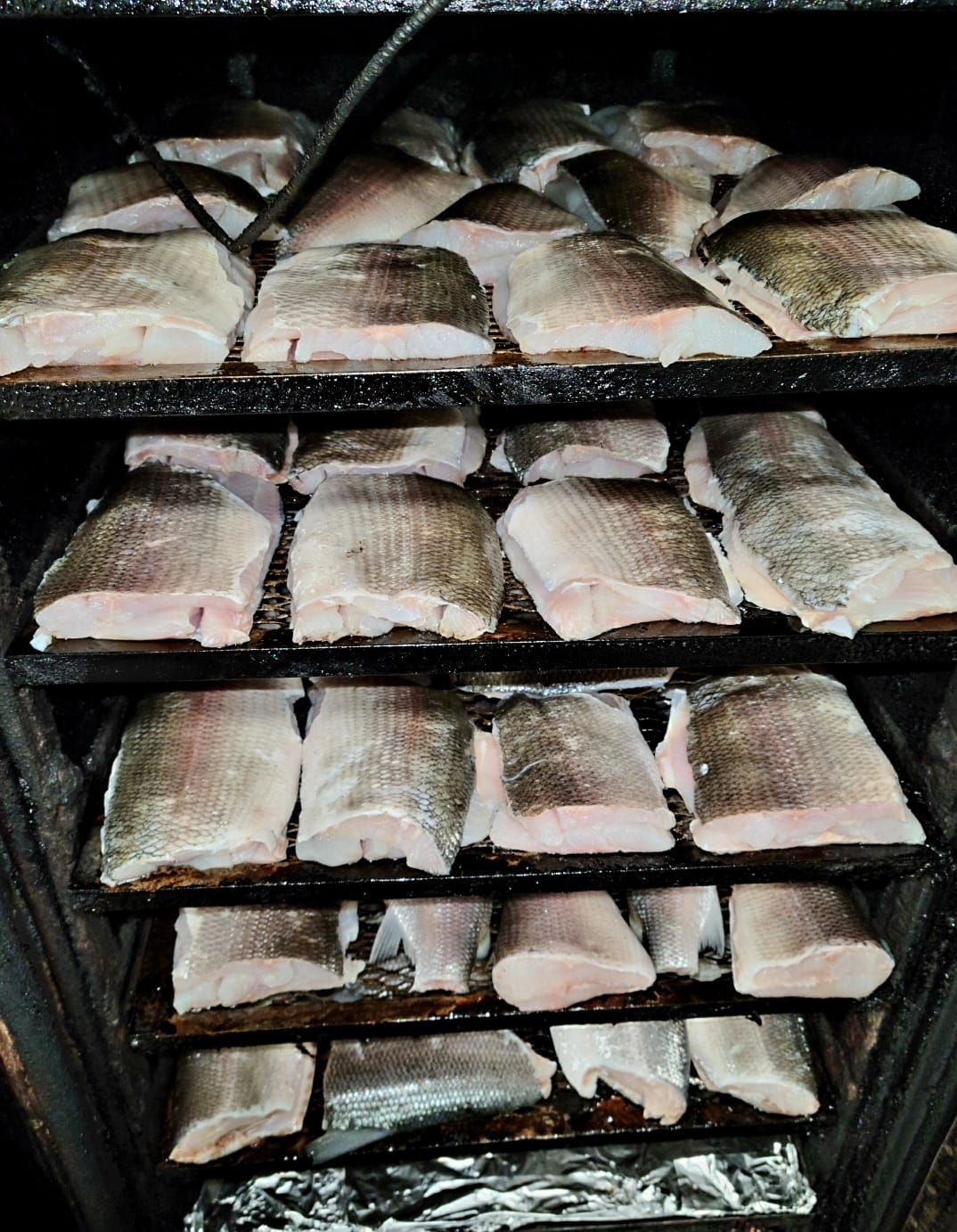 Fresh whitefish loaded into the smoker