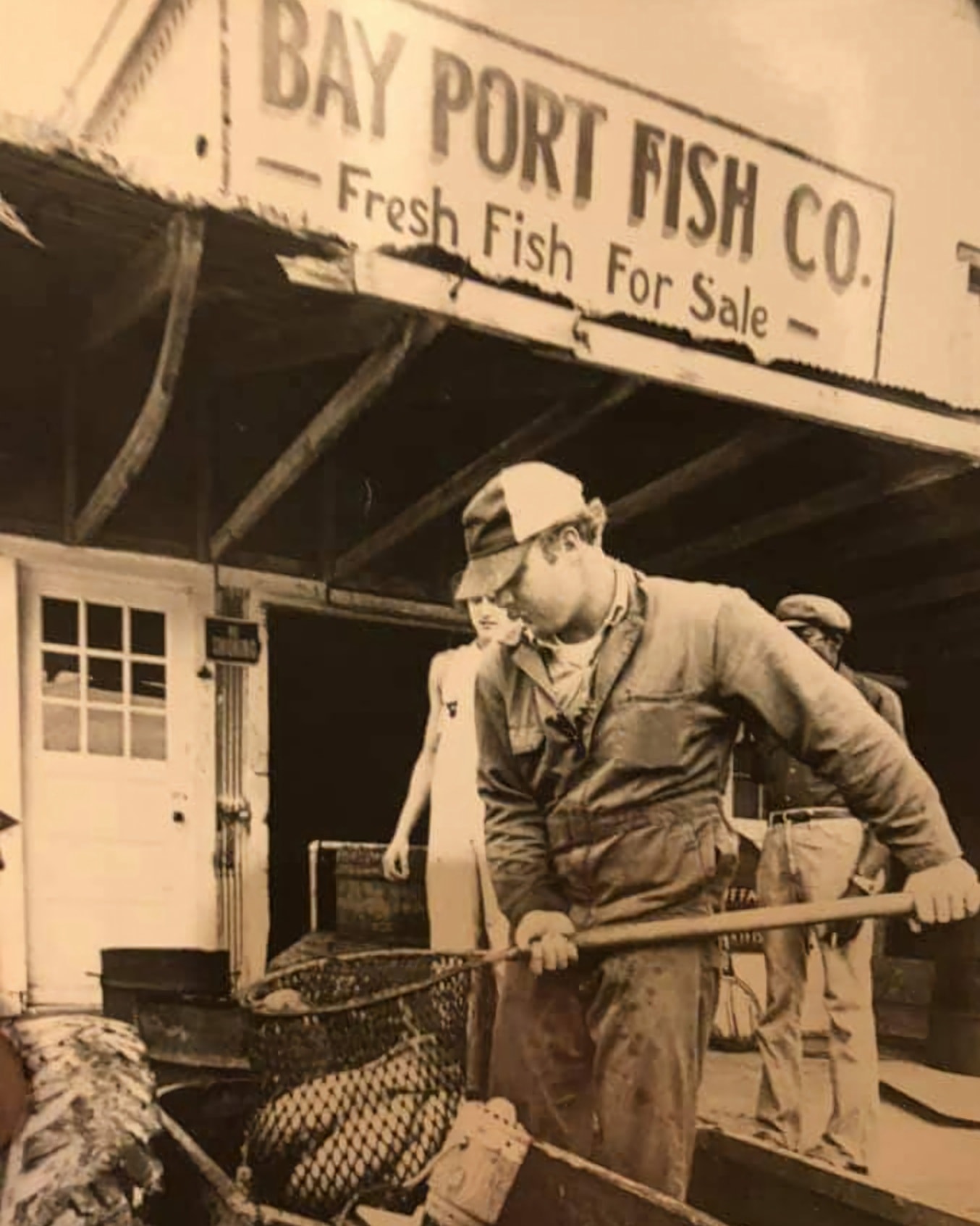 A couple of old fisherman holding a net.