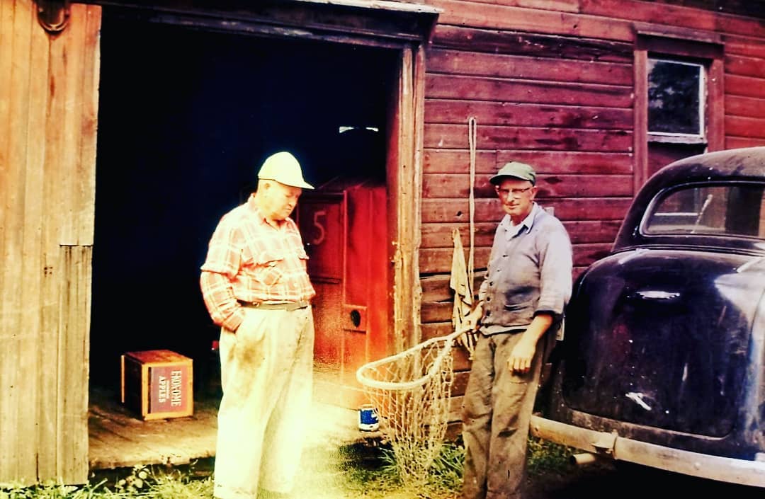 A couple of old fisherman holding a net.